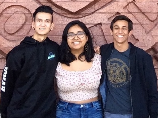 Photo of a three high school students standing in front of their school: a male, female, and male Photo of a three high school students standing in front of their school: a male, female, and male